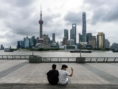 شخصان يجلسان أمام مباني حي لوجياتسوي المالي، منطقة بودونغ، شنغهاي، الصين - بلومبرغ