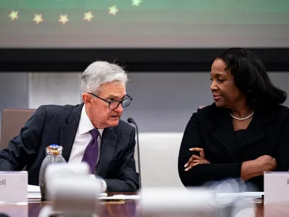 جيروم بأول، رئيس \"الاحتياطي الفيدرالي\" الأميركي متحدثاً مع ليزا كوك، عضو مجلس محافظي البنك المركزي - بلومبرغ