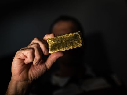 شخص يحمل سبيكة ذهب مصنعة في دار تداول ذهب بمدينة بوكوني في ولاية ماتو غروسو البرازيلية - المصدر: بلومبرغ