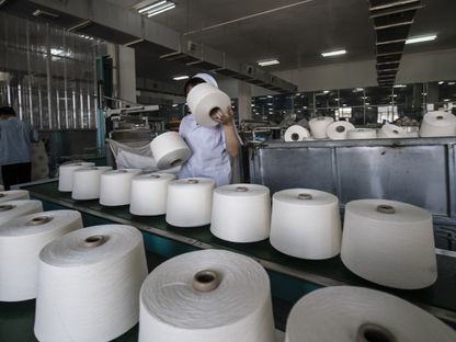 عامل يتعامل مع لفائف الغزل على خط إنتاج في مصنع شركة (Fujian Strait Textile Technology Co) في بوتيان، مقاطعة فوجيان، الصين - بلومبرغ