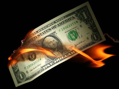 صورة توضيحية لورقة نقدية أميركية فئة دولار واحد تحترق - غيتي إيمدجز