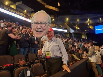 أحد الحضور يحمل لوحة بصورة وارن بافيت، رئيس مجلس الإدارة والرئيس التنفيذي لشركة بيركشاير هاثاواي، خلال اجتماع المساهمين السنوي للشركة في أوماها، نبراسكا، الولايات المتحدة، يوم السبت 4 مايو 2024 - بلومبرغ