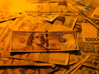 أوراق نقدية من الوون الكوري الجنوبي إلى جانب ورقة من فئة 100 دولار أميركي - بلومبرغ