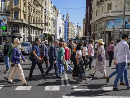 متسوقون يعبرون الطريق في منطقة 'غران فيا' بمدريد، إسبانيا - المصدر: بلومبرغ