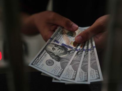 عامل يحمل أوراقًا من فئة الدولار الأميركي في مكتب صرافة بجاكرتا إندونيسيا يوم الأربعاء 2 مارس 2022. - المصدر: بلومبرغ