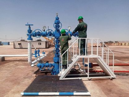 فنيان يضبطان صمام التحكم  في موقع حقل صدد الغازي بريف حمص، سوريا (المصدر: وزارة النفط والثروة المعدنية السورية) - الشرق