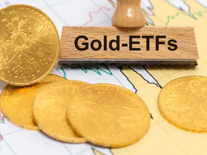 صورة تعبيرية تضم مجموعة من العملات الذهبية مع ختم خشبي مكتوب عليه \"صناديق الاستثمار المتداولة في الذهب\" باللغة الإنجليزية. - رويترز