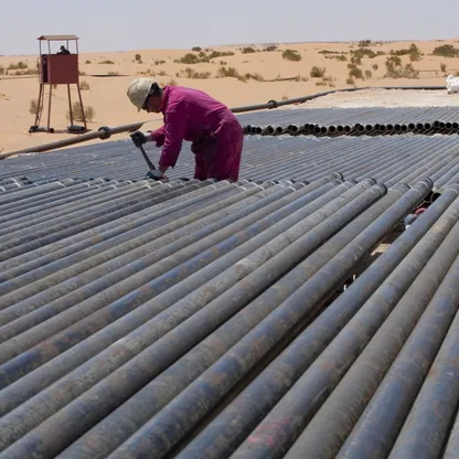 عامل يضبط مسننات عدد من الأنابيب في منطقة حاسي مسعود الغنية بالنفط في شرق الجزائر - Getty Images