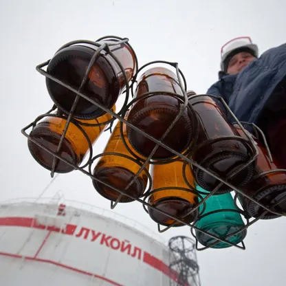 عامل يحمل مجموعة مختارة من عينات الزيوت أمام خزان نفط في مصفاة  تابعة لشركة "لوك أويل" في نيجني نوفغورود، روسيا - المصدر: بلومبرغ