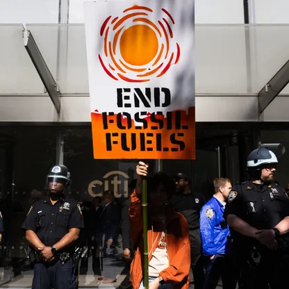 ناشط في قضايا المناخ يحمل لافتة خلال احتجاج خارج مقر "سيتي غروب" في يونيو 2024 - بلومبرغ