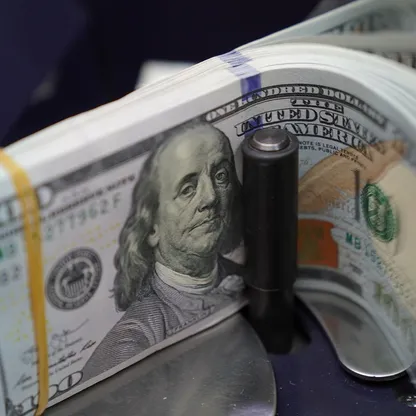 أوراق نقدية من الدولار الأميركي في ماكينة عد نقود بمكتب صرافة في جاكرتا، إندونيسيا. - بلومبرغ