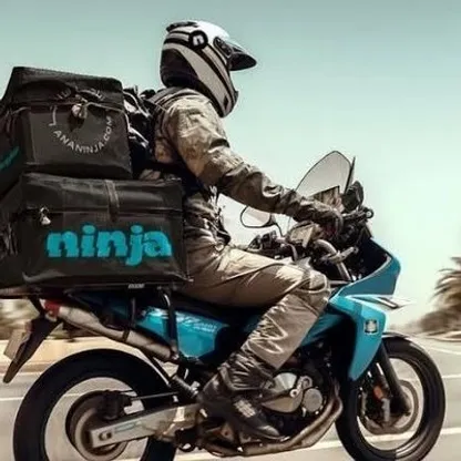 عامل توصيل يقود دراجة عليها شعار شركة نينجا السعودية - الشرق