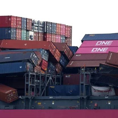 مشهد فوضوي يُظهر انهيار حمولة سفينة من حاويات الشحن (صورة تعبيرية غير مؤرخة) - المصدر: بلومبرغ