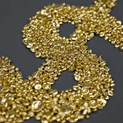 حبيبات من الذهب مجمعة على هيئة علامة الدولار الأميركي. رغم الحرب وارتفاع النفط، ضغط التضخم والدولار القوي على الذهب فأبقياه قرب 5200 دولار - المصدر: بلومبرغ