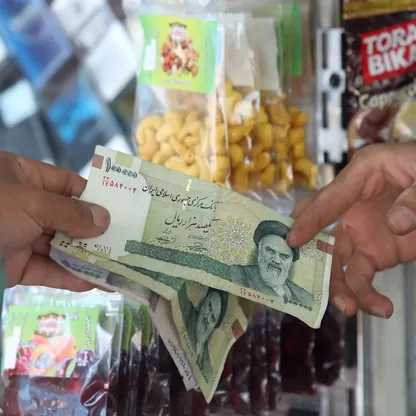 رجل يدفع بالريال الإيراني في متجر بطهران. - Getty Images