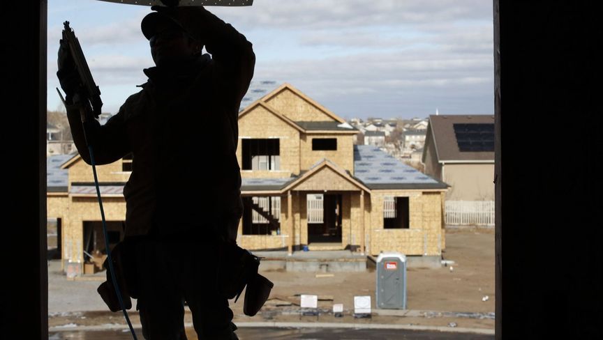عامل يضبط إطار نافذة في مبنى قيد الإنشاء بمدينة ليهي في ولاية يوتا الأمريكية - المصدر: بلومبرغ