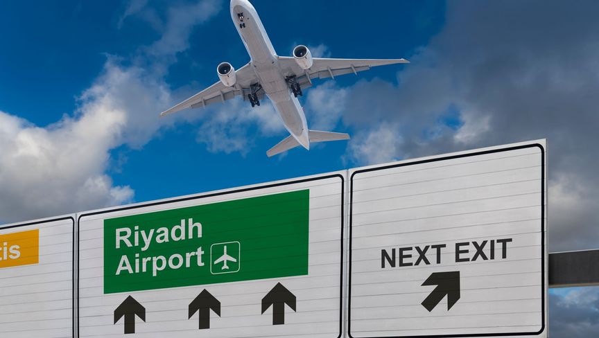 لافتة تشير إلى اتجاه مطار الرياض فيما تبدو في الجو طائرة أقلعت حديثاً  - المصدر: غيتي إيمجز