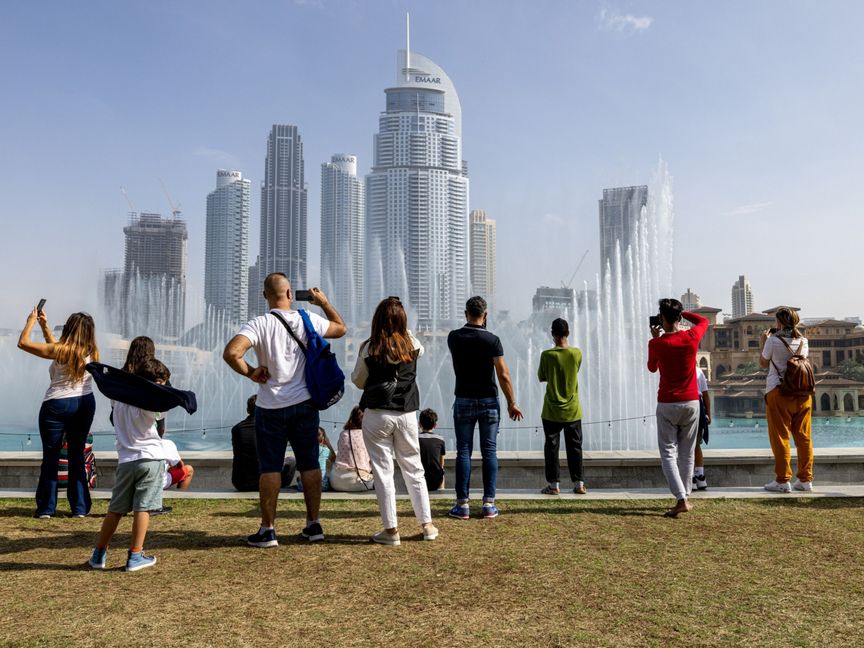 سياح يستمتعون بعرض نافورة مياه بالقرب من برج خليفة، في دبي، الإمارات العربية المتحدة، يوم الأحد، 2 يناير 2022.  - المصدر: بلومبرغ
