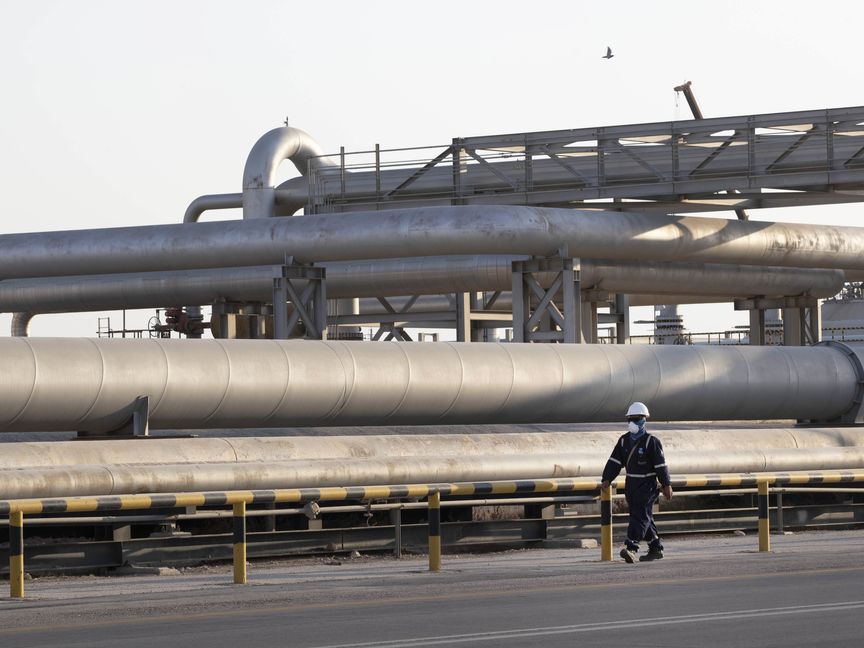 عامل يمر أمام خط أنابيب لنقل النفط تابع لشركة "أرامكو" السعودية في منشأة معالجة الخام "أبقيق"، بتاريخ 20 سبتمبر 2019 - المصدر: بلومبرغ