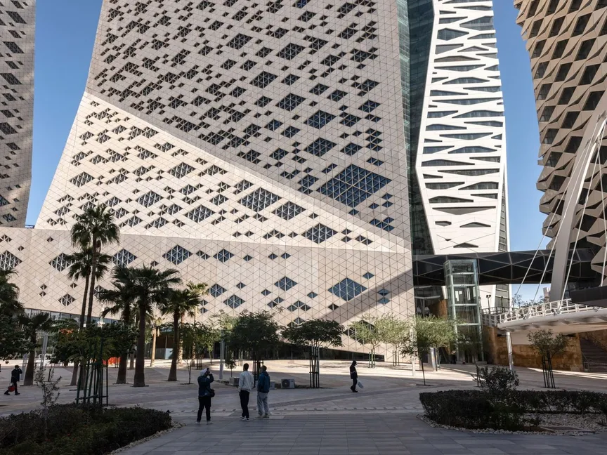 أشخاص يتجولون قرب ناطحات السحاب في مركز الملك عبدالله المالي بالعاصمة السعودية الرياض - المصدر: بلومبرغ