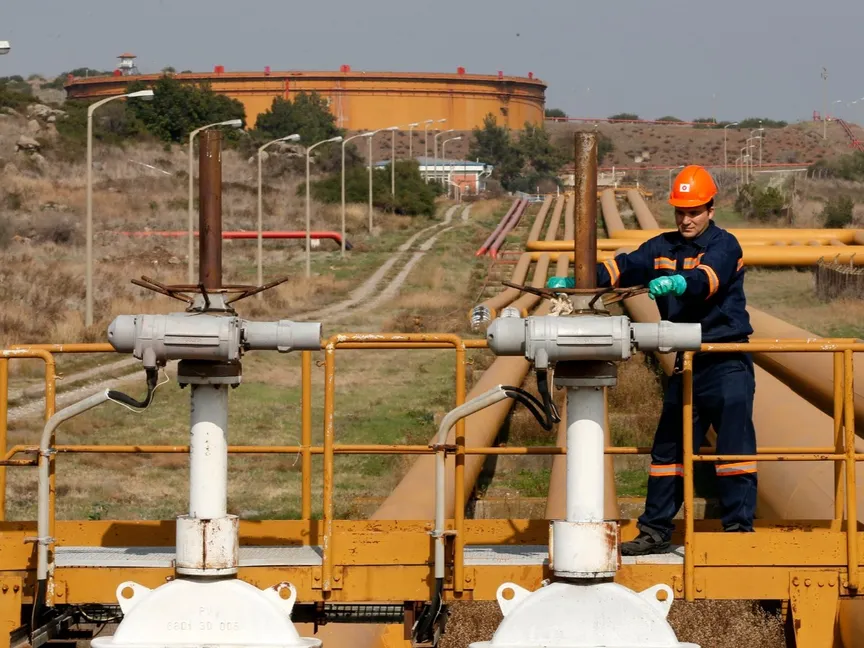 عامل يقوم بفحص آليات الصمامات الخاصة بالأنابيب المتصلة بخزانات النفط في ميناء جيهان التركي على البحر الأبيض المتوسط - رويترز 