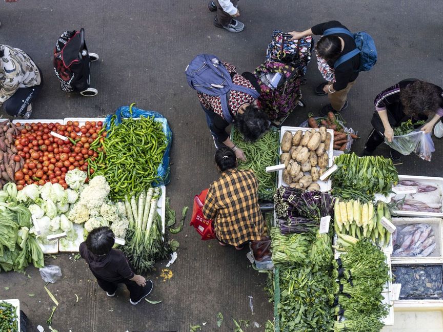 عملاء يتسوقون الخضراوات في سوق بمنطقة قرية جيوشيا، شنتشن، الصين - المصدر: بلومبرغ