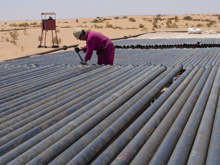 عامل يضبط مسننات عدد من الأنابيب في منطقة حاسي مسعود الغنية بالنفط في شرق الجزائر - Getty Images