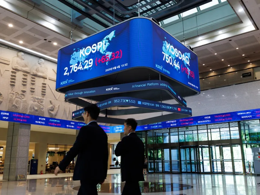 شخصان يطالعان مؤشر أسعار الأسهم الكورية المركب "كوسبي" في بورصة كوريا الجنوبية - بلومبرغ