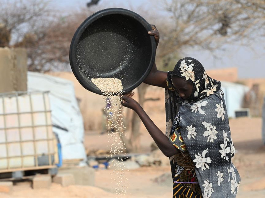 إمرأة تجهز كمية من الحبوب لوجبة غذائية في مخيم للنازحين في أولام، النيجر، في 3 مايو 2022. - المصدر: بلومبرغ