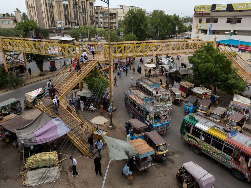 مواطنون يعبرون فوق جسر للمشاة تحت تقاطع مروري في كراتشي ، باكستان - المصدر: بلومبرغ