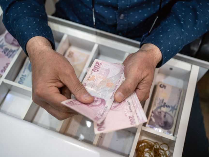 بائع يعد أوراقاً نقدية من الليرة التركية داخل متجر بالعاصمة أنقرة في تركيا  - المصدر: بلومبرغ