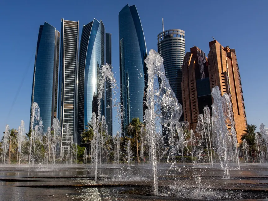 أبراج الاتحاد الشاهقة وهي تحلق في سماء أبوظبي، وتحيط بها نافورات مائية ترقص بإيقاع متناغم - بلومبرغ