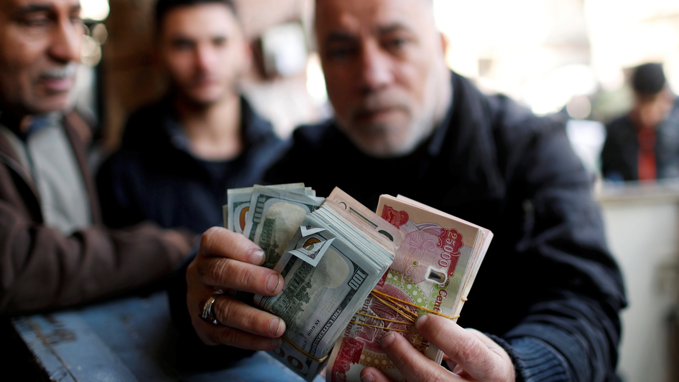 تقرير: العراق يوافق على وقف تدفقات الدولار لجماعات موالية لإيران 