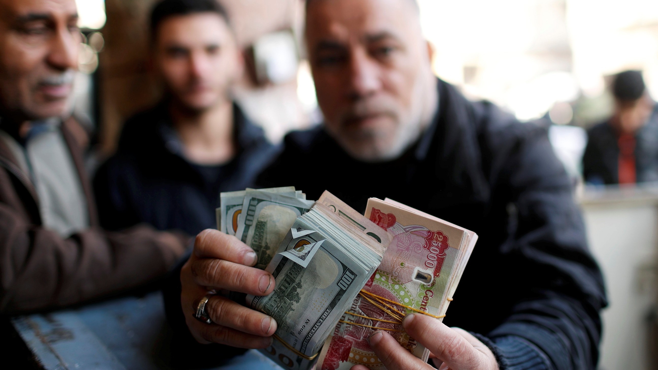 العراق يخفض سعر صرف الدينار نحو 16% بعد أشهر من الضغوط المالية 