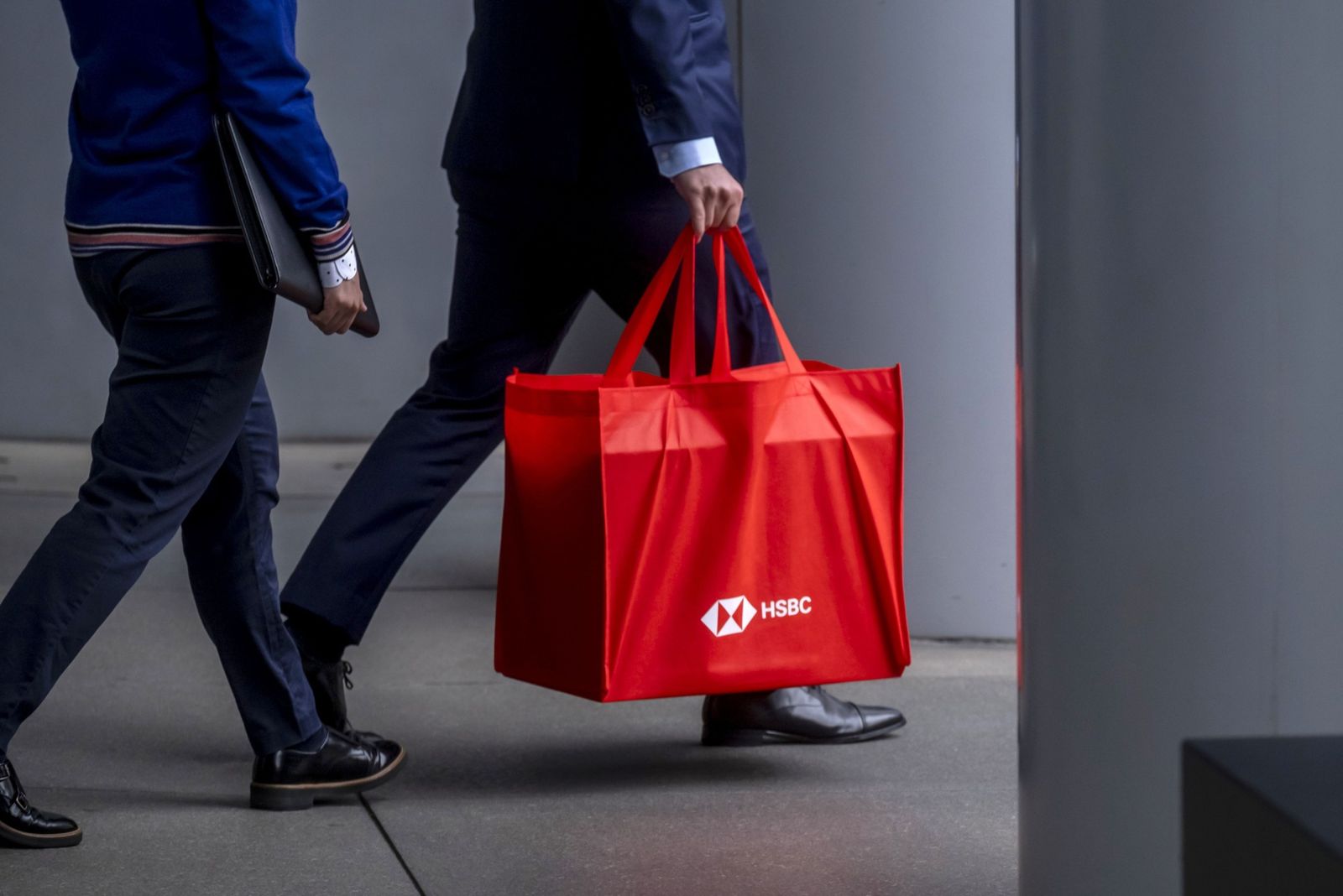 عميل يحمل حقيبة عليها شعار HSBC خارج المقر الرئيسي للبنك في هونغ كونغ - المصدر: بلومبرغ