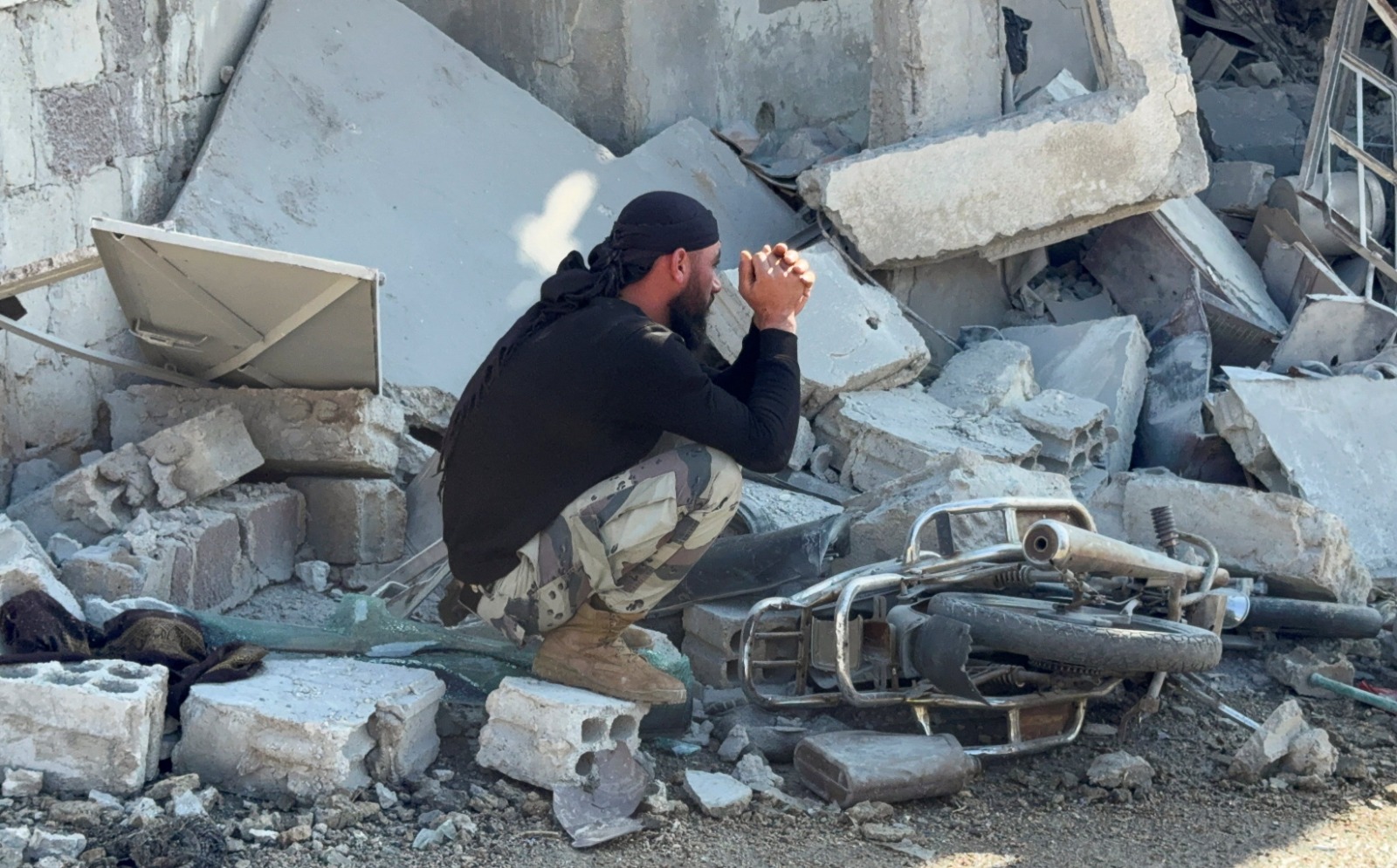 يجلس رجل على الأنقاض في موقع متضرر عقب غارة إسرائيلية في سوريا. 28 نوفمبر 2025 - "رويترز"