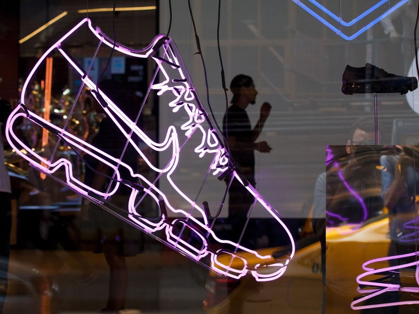 موظف لدى 'نايكي' يظهر وراء واجهة متجر لها في سوهو في نيويورك. الشركة تعتبر التحقيق بشأنها الضريبي بلا أساس - المصدر: بلومبرغ