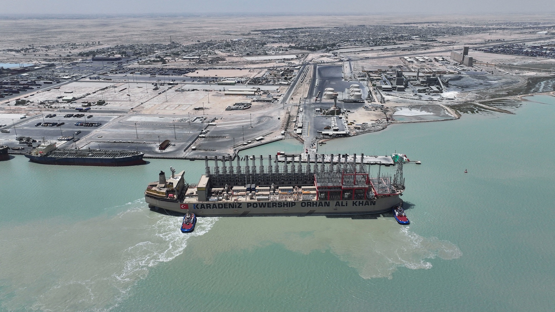 صورة ملتقطة بطائرة مسيّرة لسفينة الطاقة العائمة 'كارادينيز باورشيب أورهان علي خان' (Karadeniz Powership Orhan Ali Khan)، وهي راسية في ميناء أم قصر بمحافظة البصرة في العراق، بتاريخ 21 أغسطس 2025. وكانت شركة 'كارباورشيب' (Karpowership) قد وقّعت اتفاقاً لتزويد العراق بما يصل إلى 590 ميغاواط من الكهرباء لمدة 71 يوماً. رويترز
