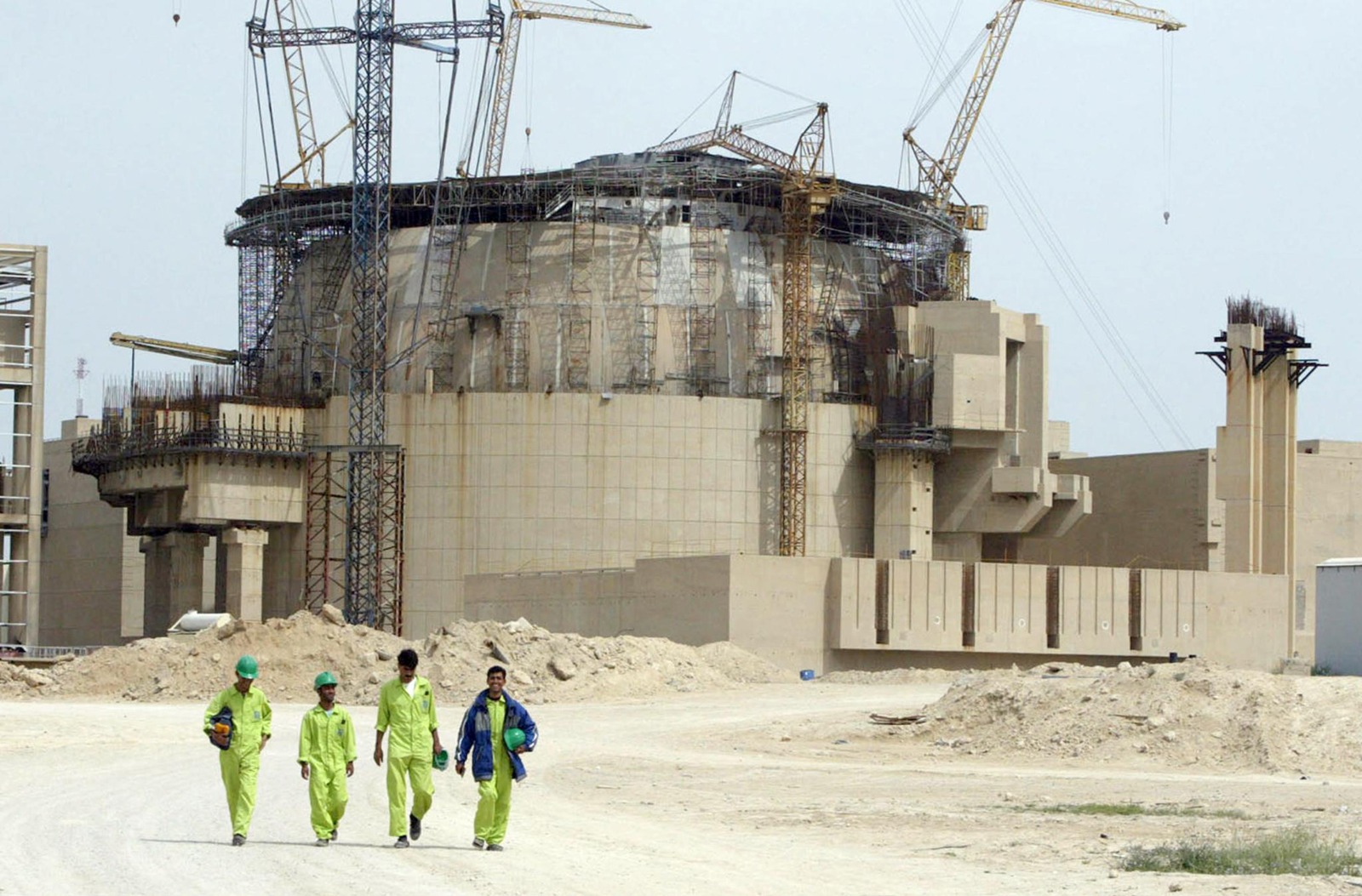 عمّال إيرانيون يسيرون داخل محطة بوشهر للطاقة النووية، حين كانت قيد الإنشاء، على بعد نحو 1300 كيلومتر جنوب طهران في عام 2003 - بلومبرغ